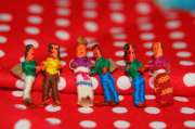 6 little human figures and a red scarf